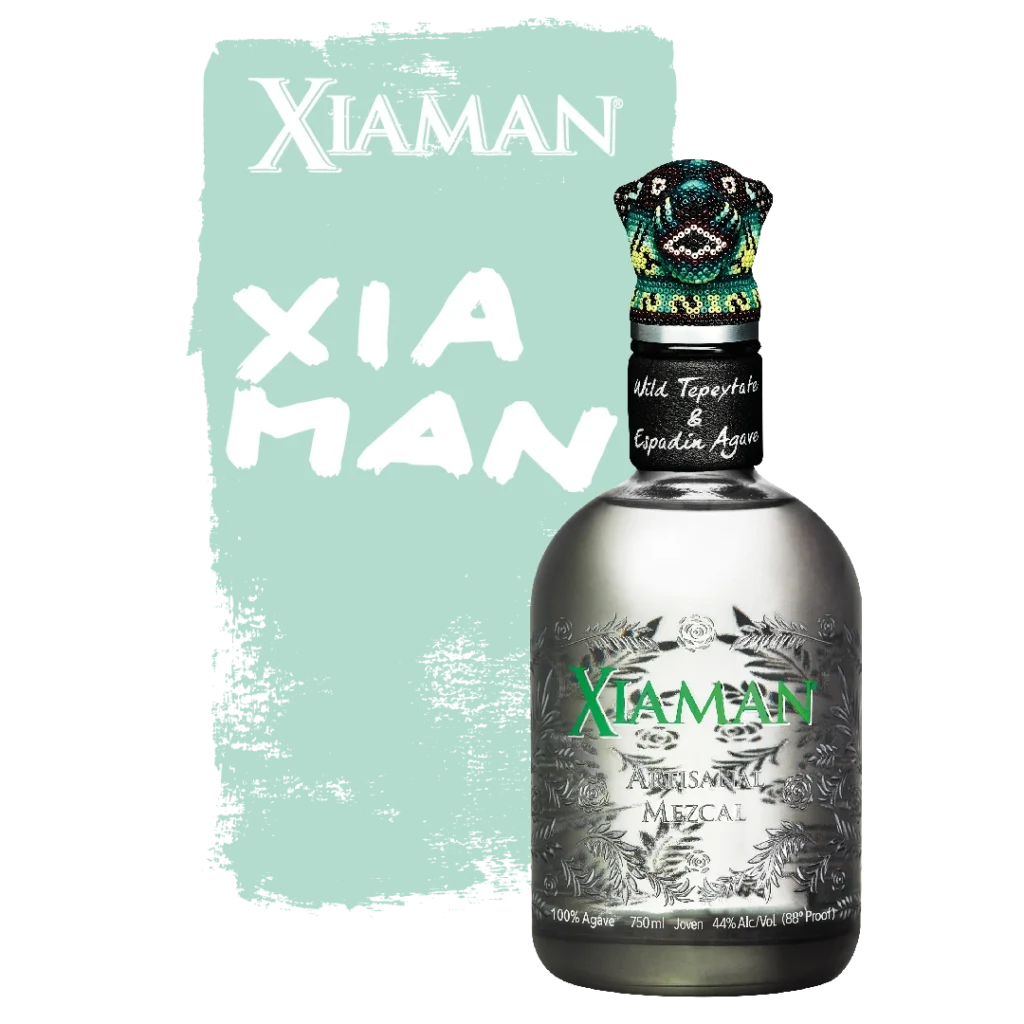 Transparent Xiaman Mezcal bottle in front of a green background that says "Xiaman" and shows the Xiaman Mezcal logo.