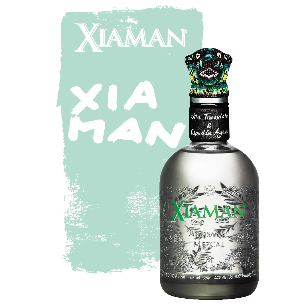 Dark grey Xiaman Mezcal 700ml bottle with green lettering and a green jaguar head bottle stopper in front of a green background.