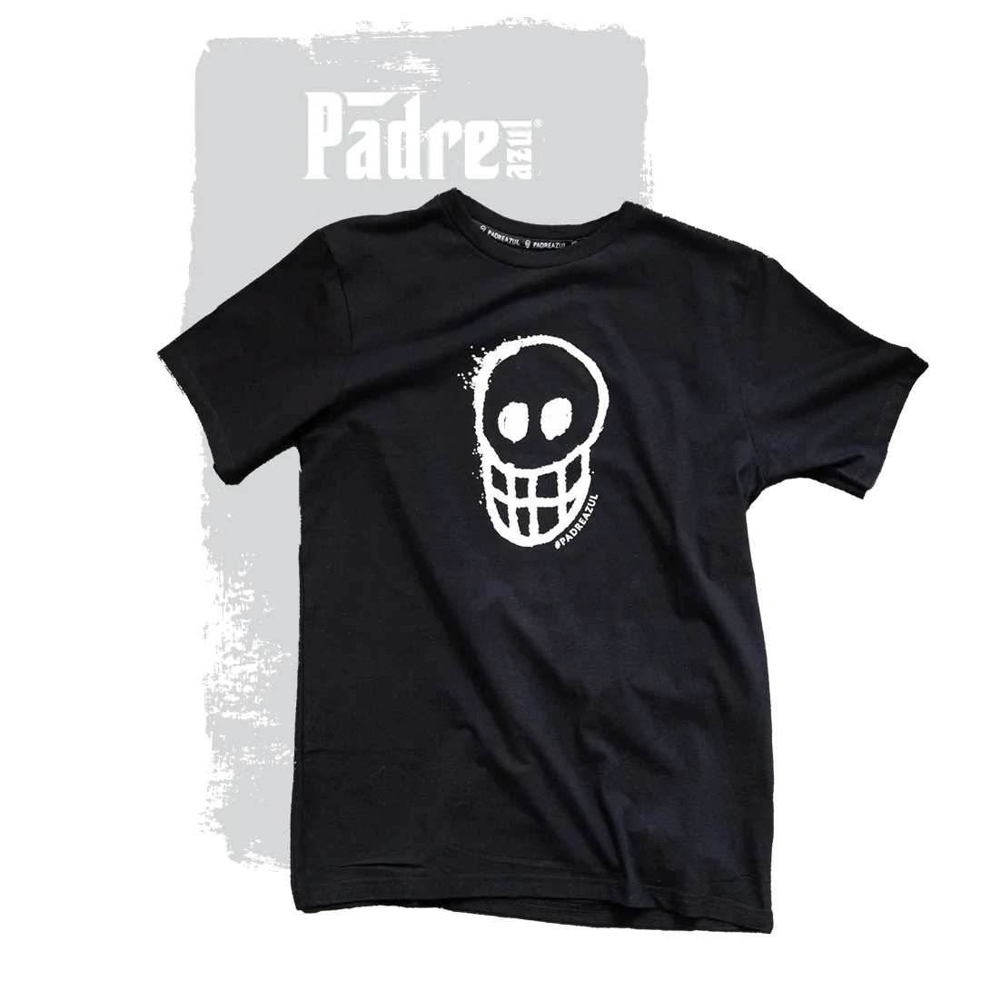 The Padre Azul T-shirt black on a grey background. In the middle of the shirt is a white skull.