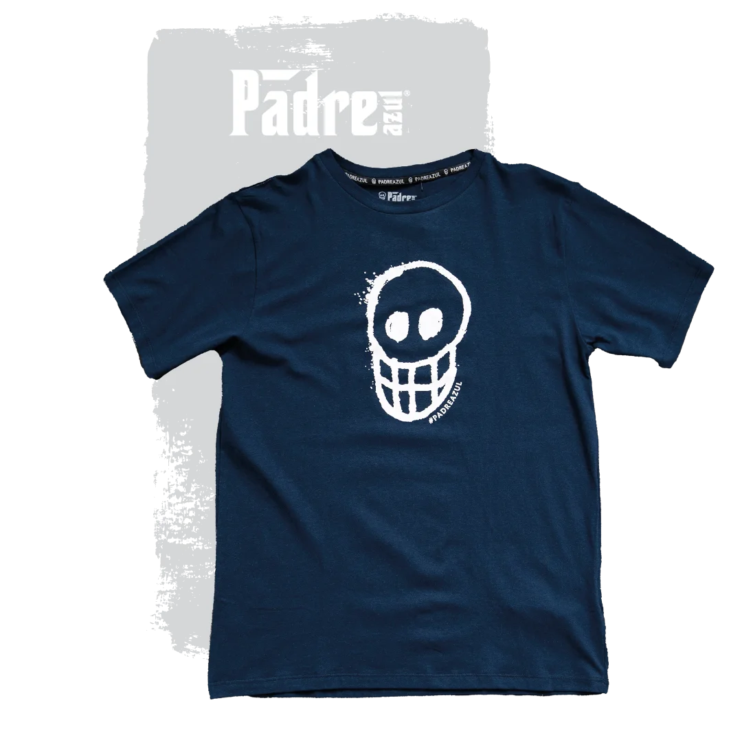 The Padre Azul T-shirt marine blue on a grey background. In the middle of the shirt is a white skull.